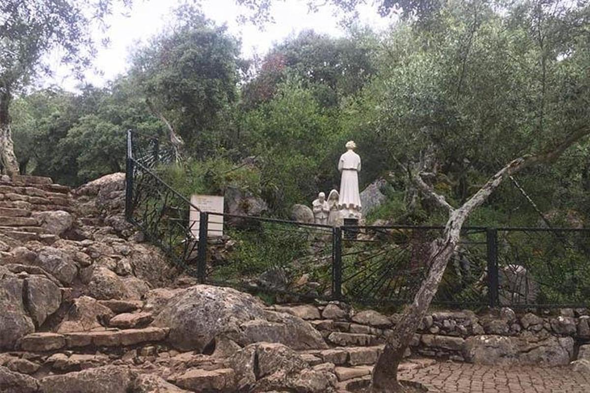 socha sedící na vrcholu skal