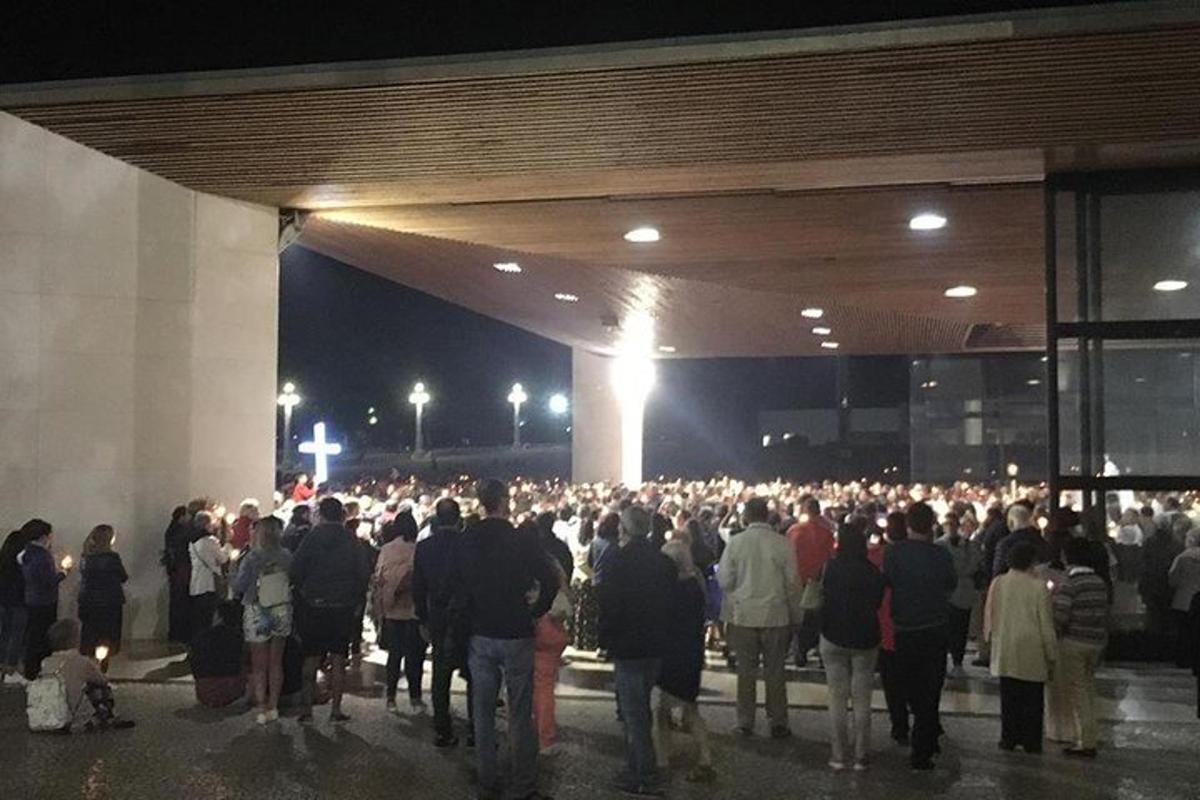 velký dav lidí stojících v noci před budovou