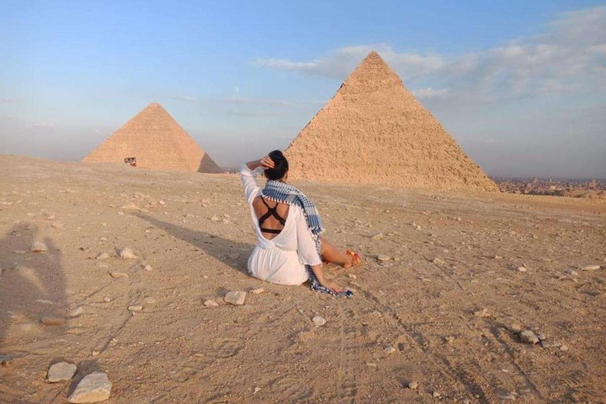 امرأة تجلس أمام الأهرامات