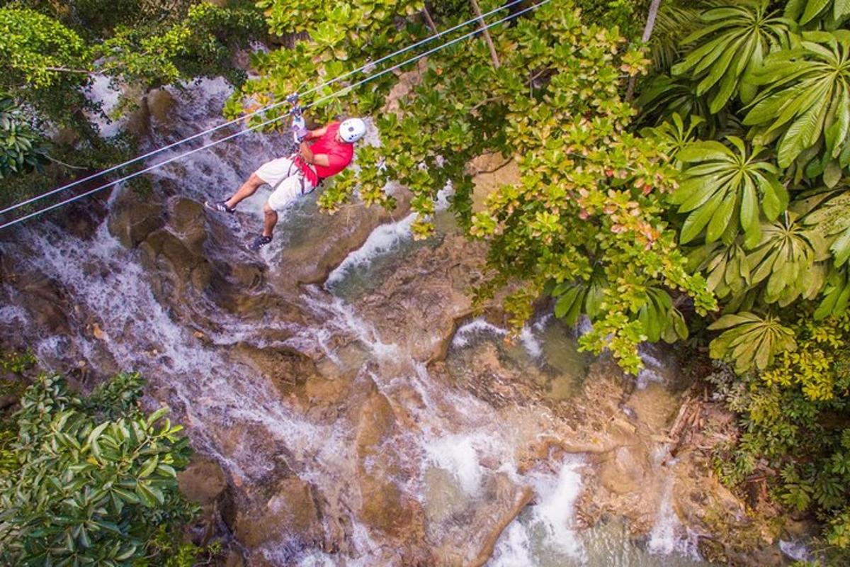 một người đàn ông đang đi trên đường trượt zipline qua thác nước