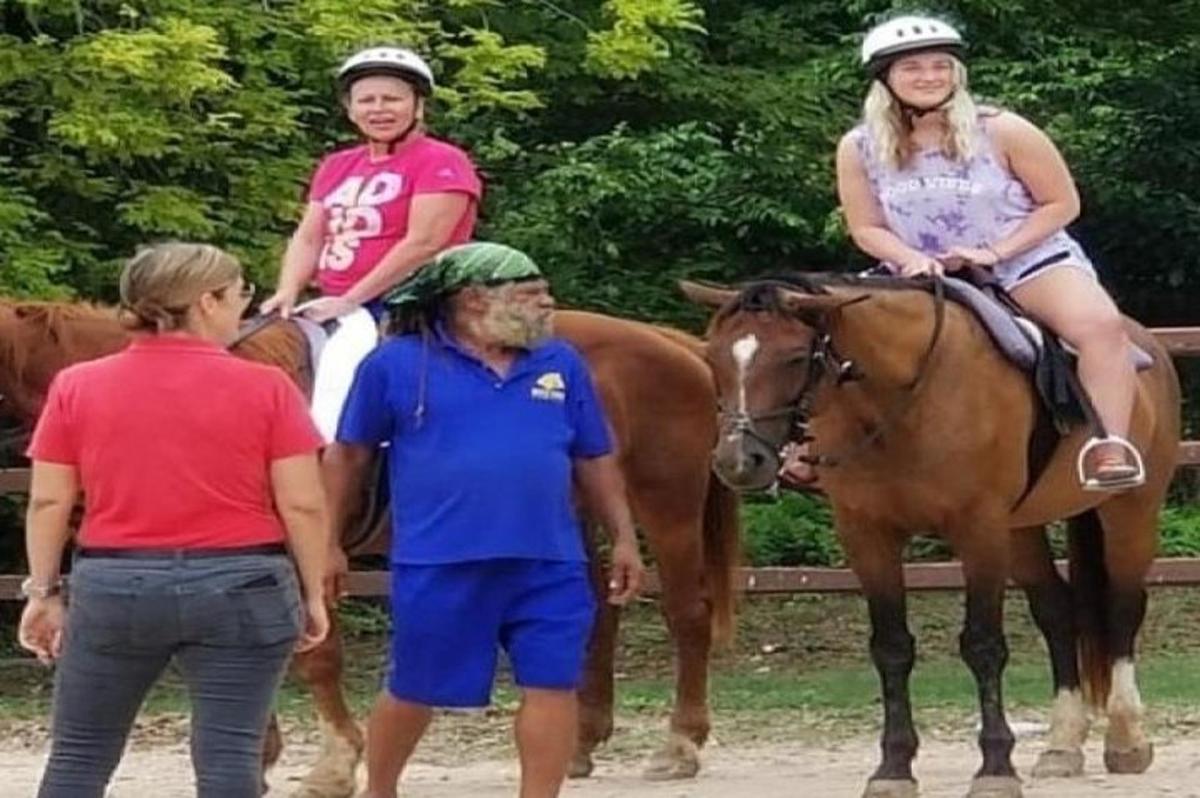 two people are sitting on a horse with a man