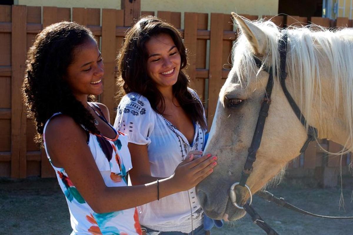 two women standing next to a white horse