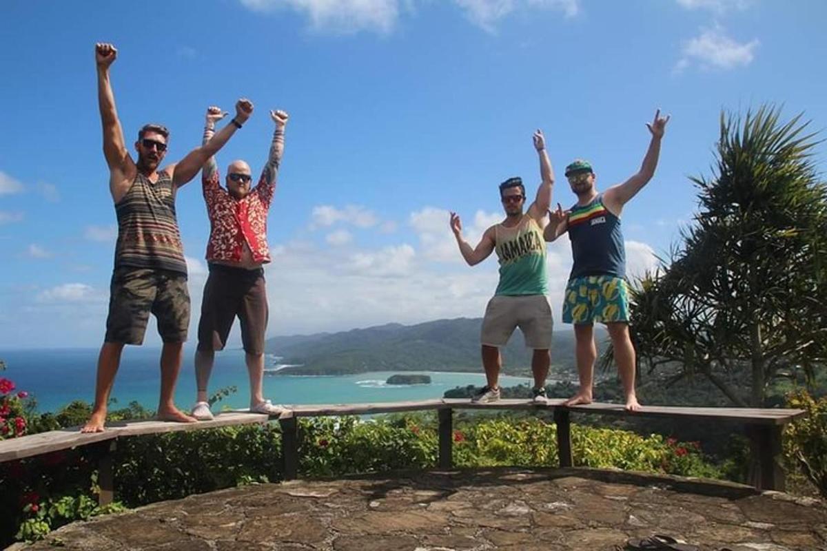 un gruppo di persone in piedi su una sporgenza con le braccia alzate