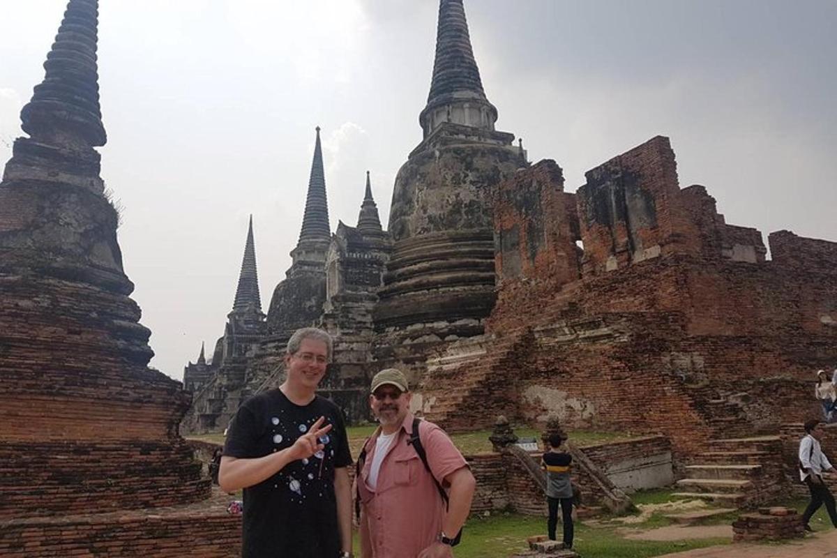 a man and woman standing in front of a temple
