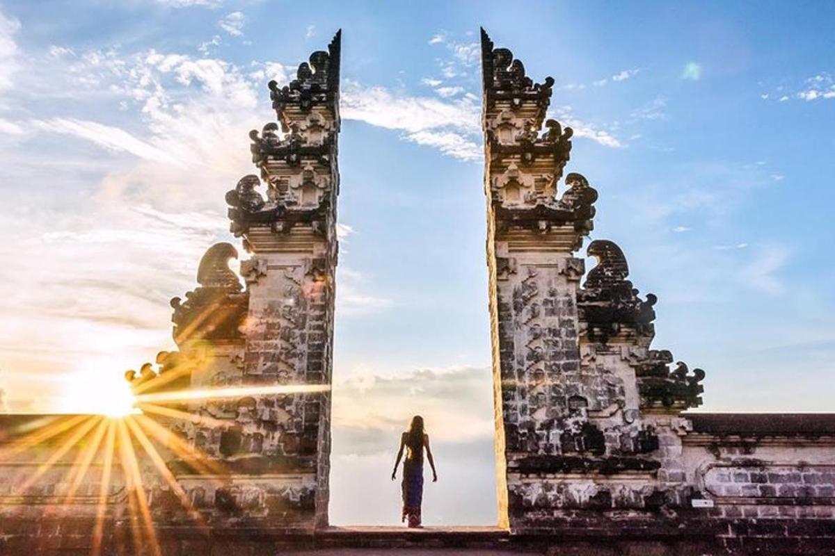 Un hombre caminando a través de una puerta al atardecer
