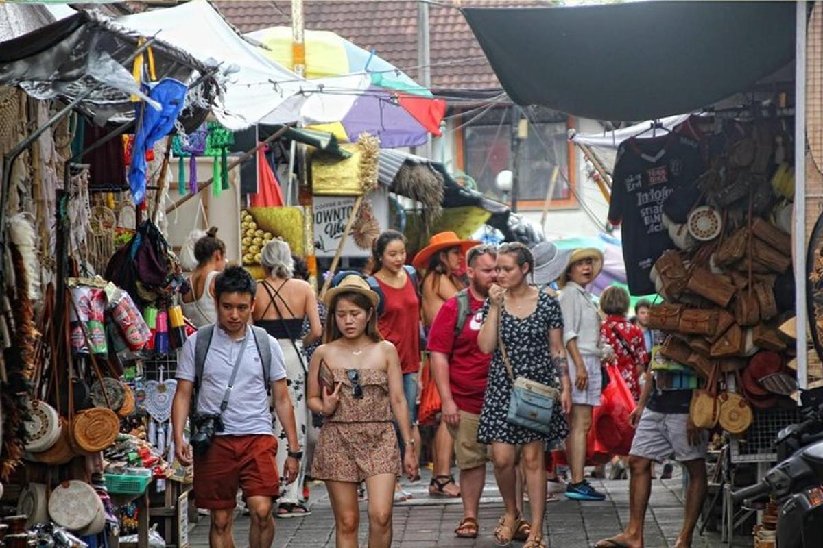 un gruppo di persone che camminano in un mercato aperto