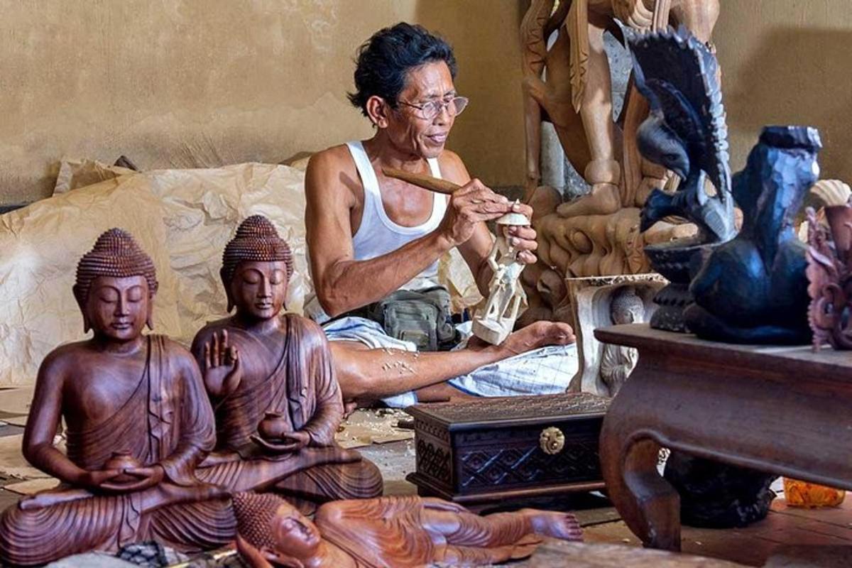 một người đàn ông đang ngồi trong một căn phòng có những bức tượng của người Ai Cập