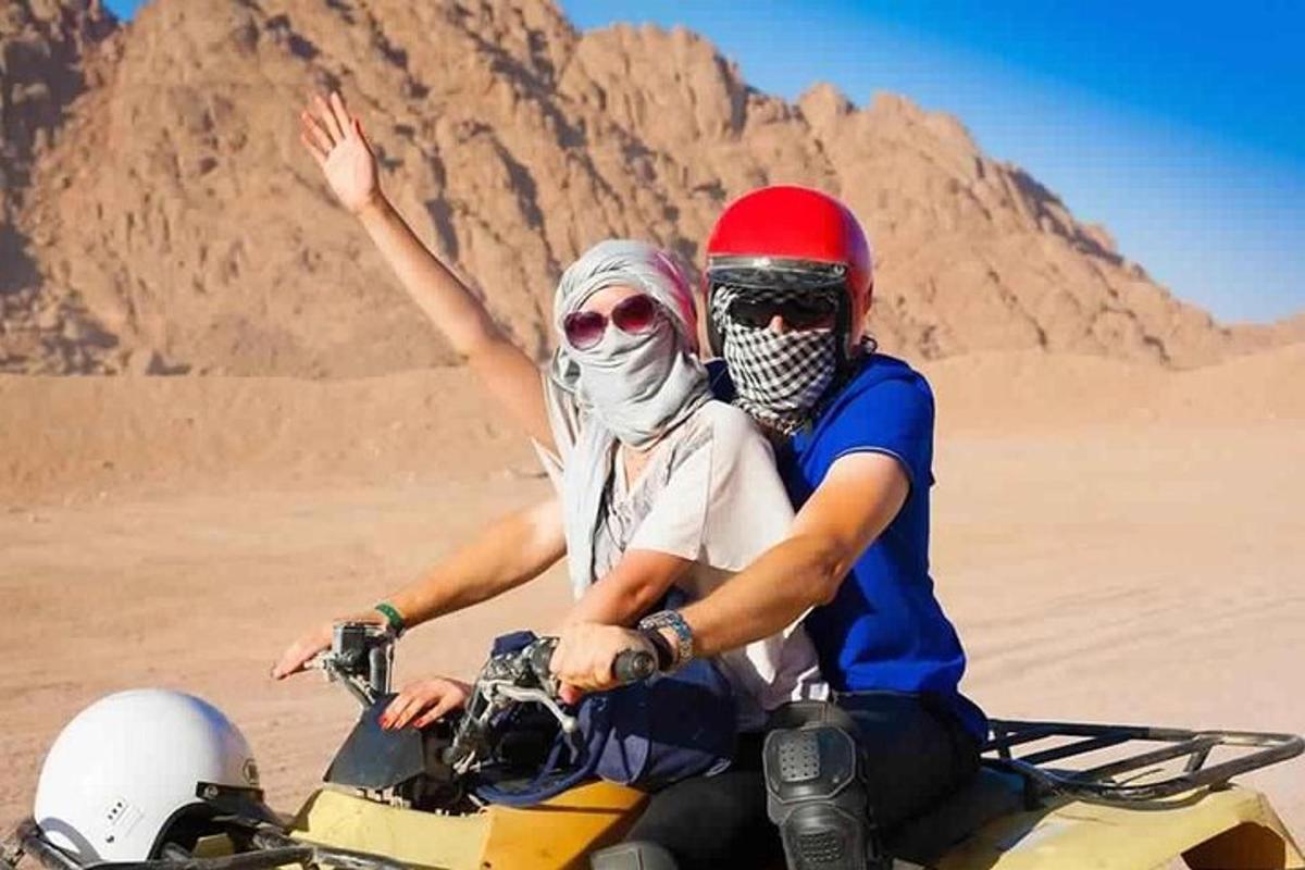 dva lidé jedoucí na motorce v poušti