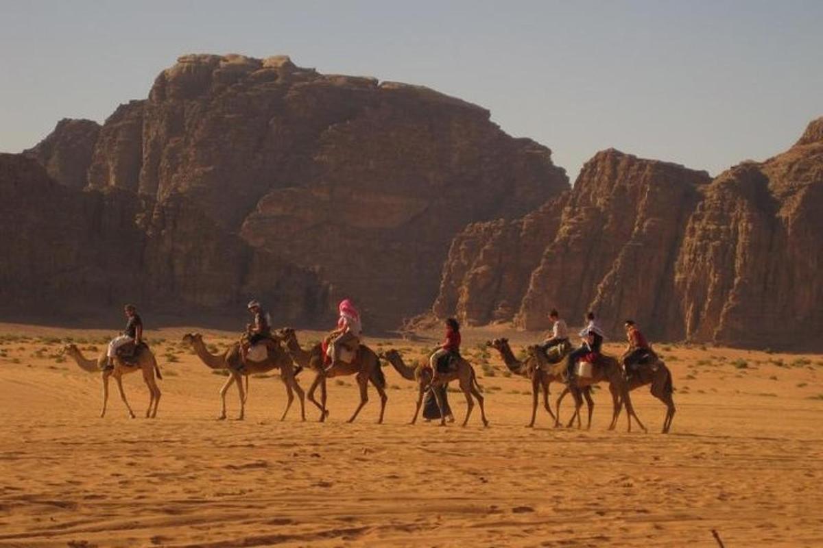 a group of people riding horses in the desert
