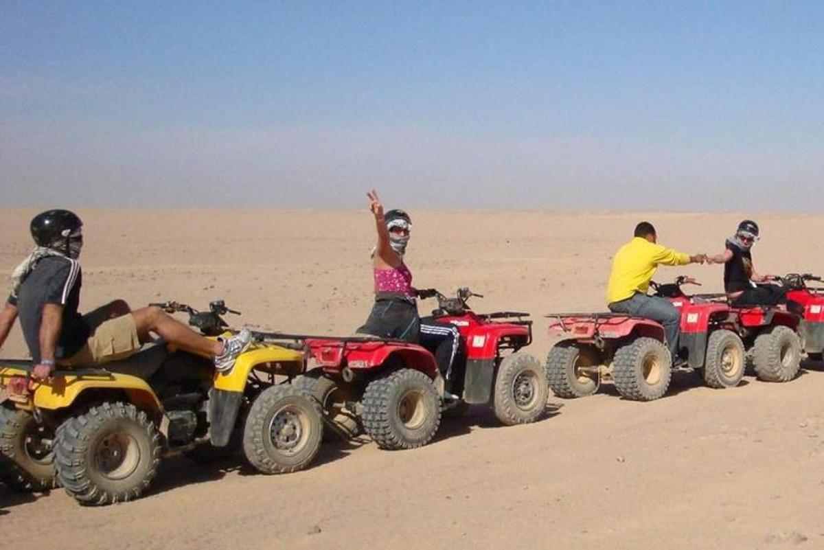 sekumpulan orang menunggang atv di padang pasir