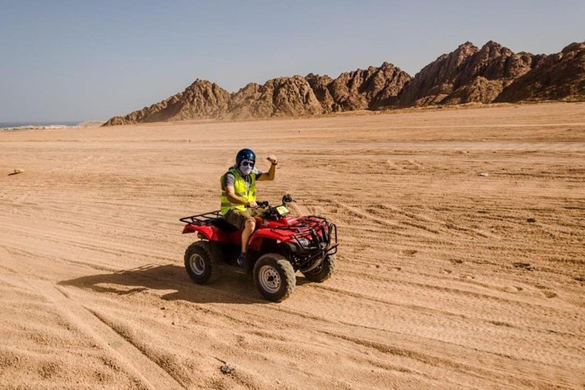 a person riding a quad bike in the desert