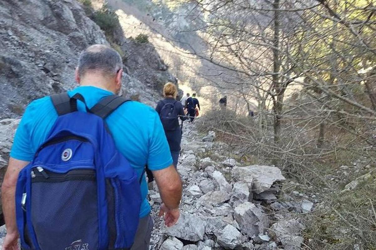 a man with a backpack walking down a rocky trail