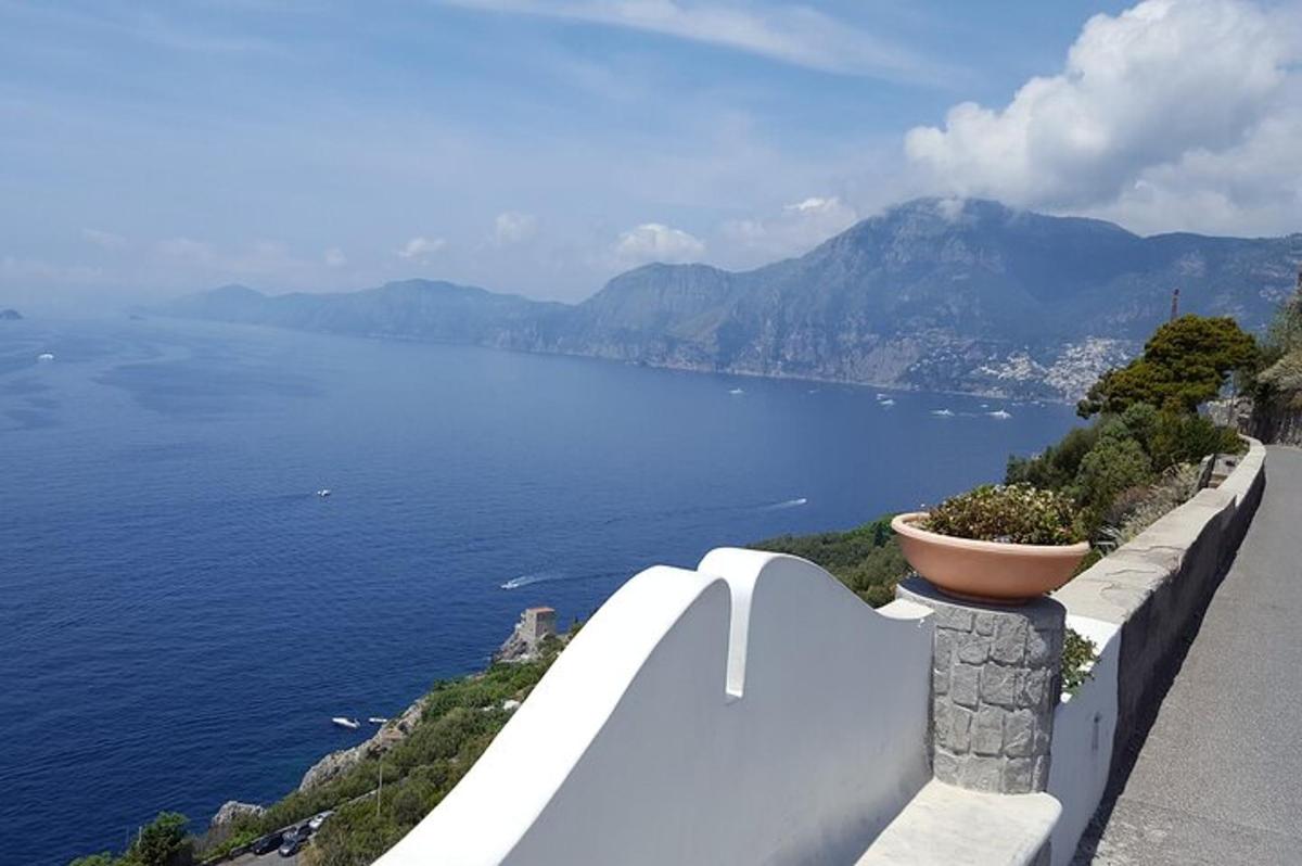 un muro di pietra con un vaso di fiori sul lato di un lago
