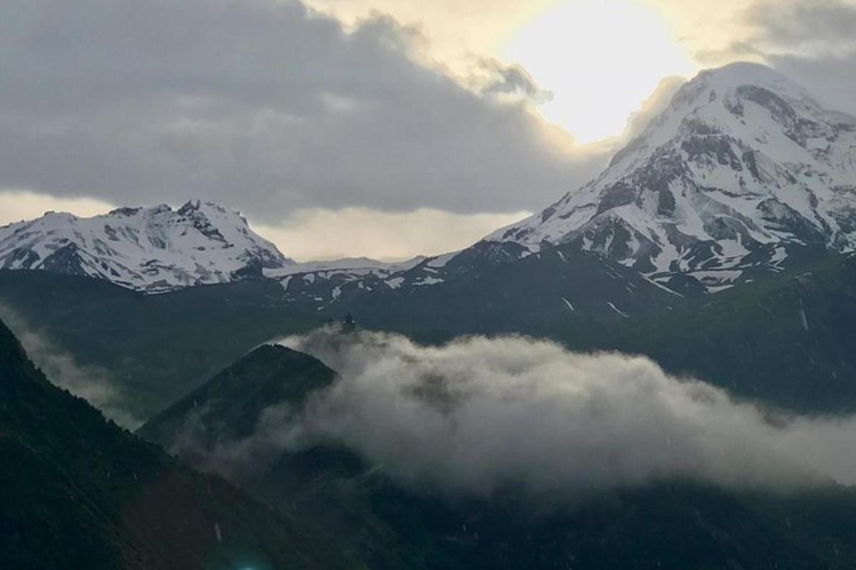 gunung yang dilitupi salji dengan awan di hadapannya