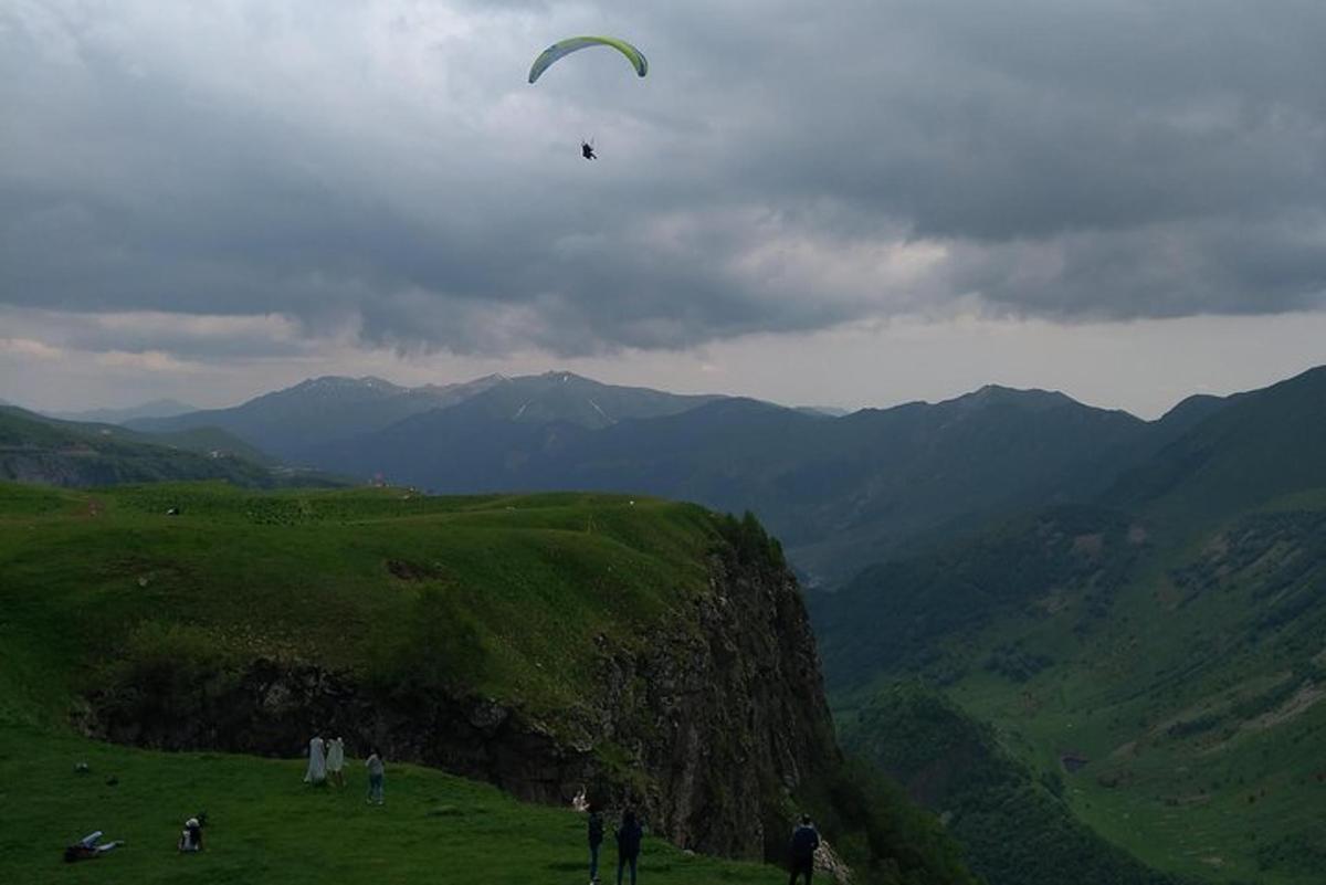 un grup de persones fent volar un estel a la muntanya