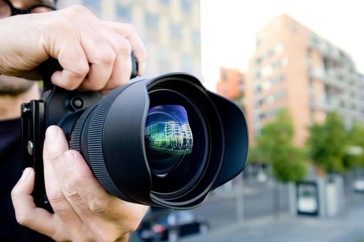 osoba držící v ruce fotoaparát