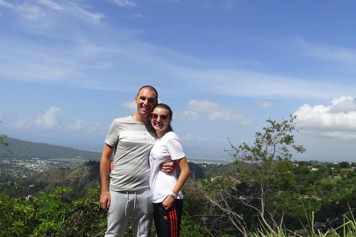 a man and woman standing on top of a hill