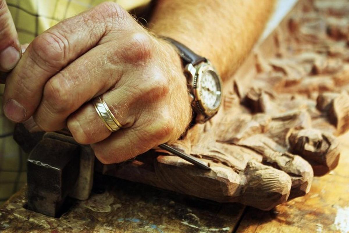 una mano con un orologio sopra un pezzo di legno