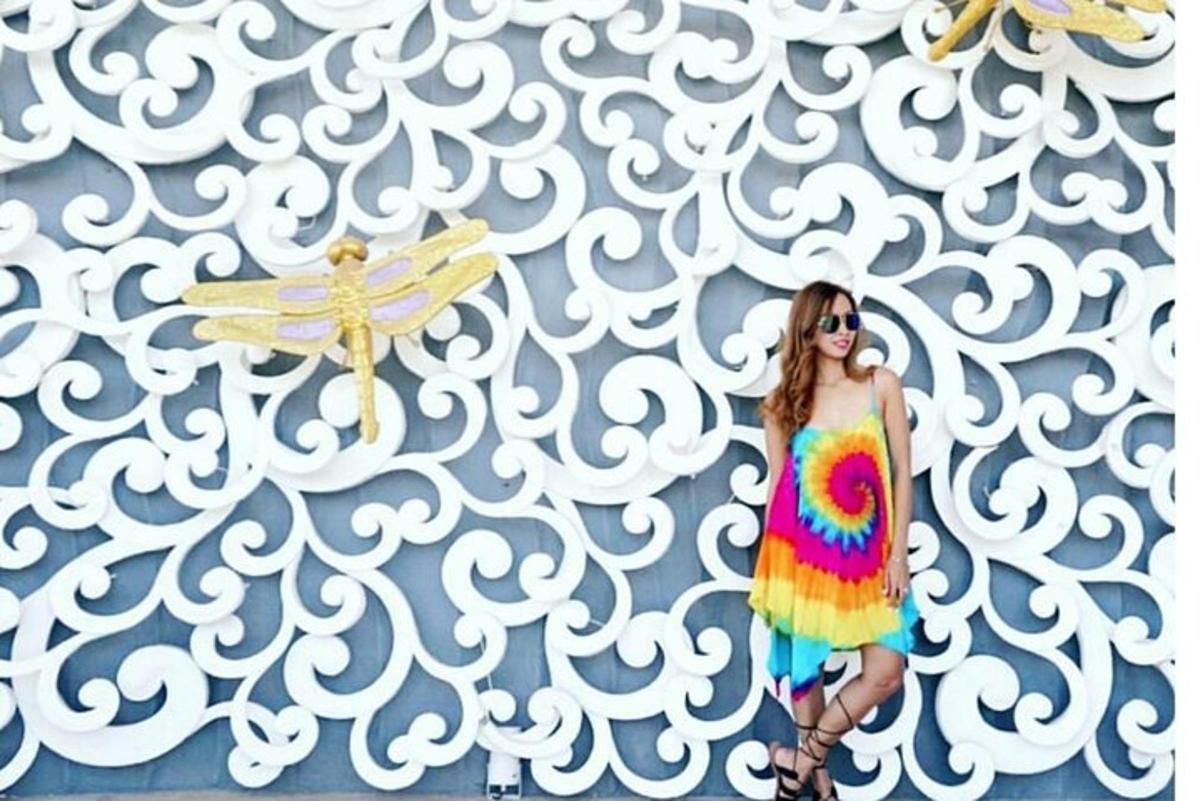 una donna in un abito colorato in piedi davanti a un muro