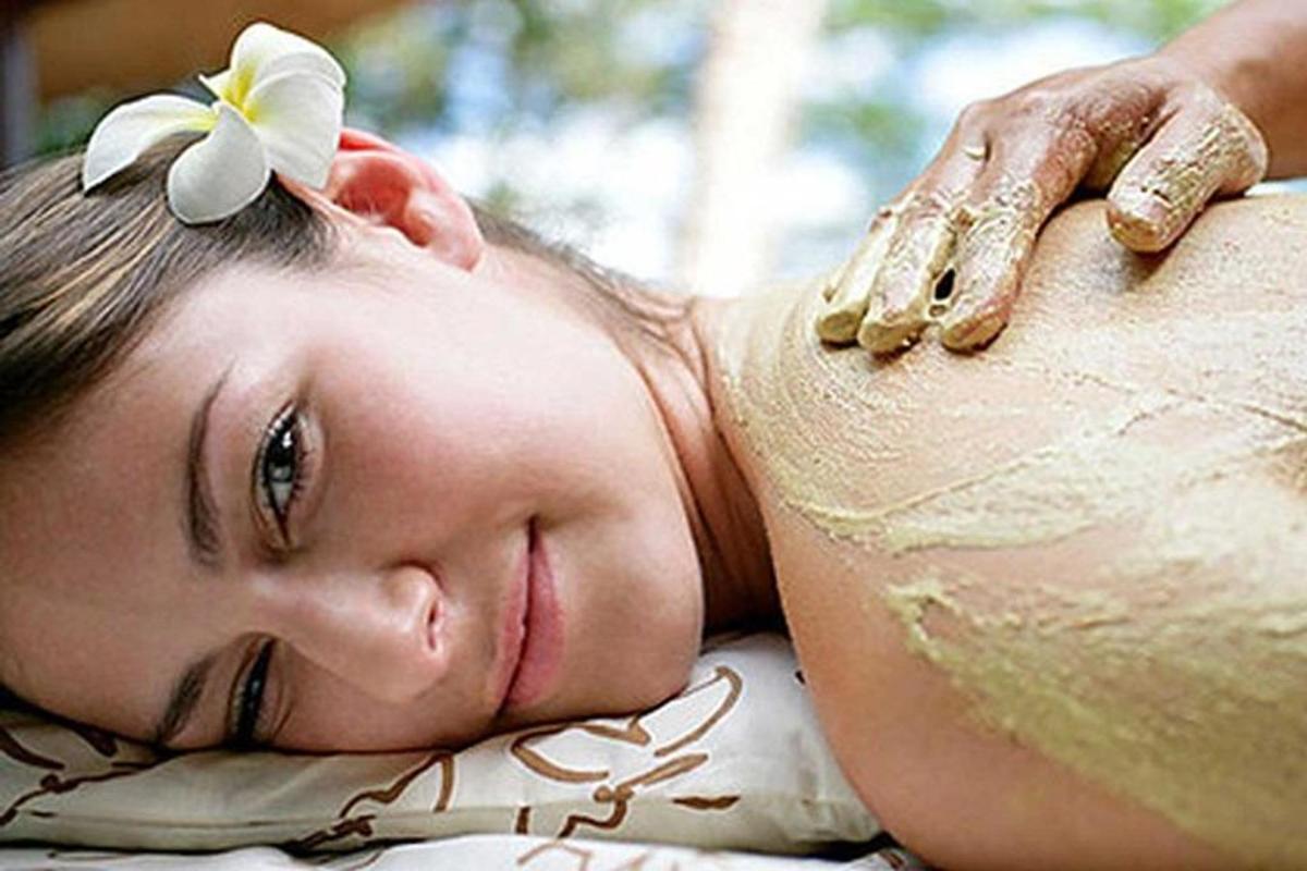 a woman laying on a pillow with a flower on her back