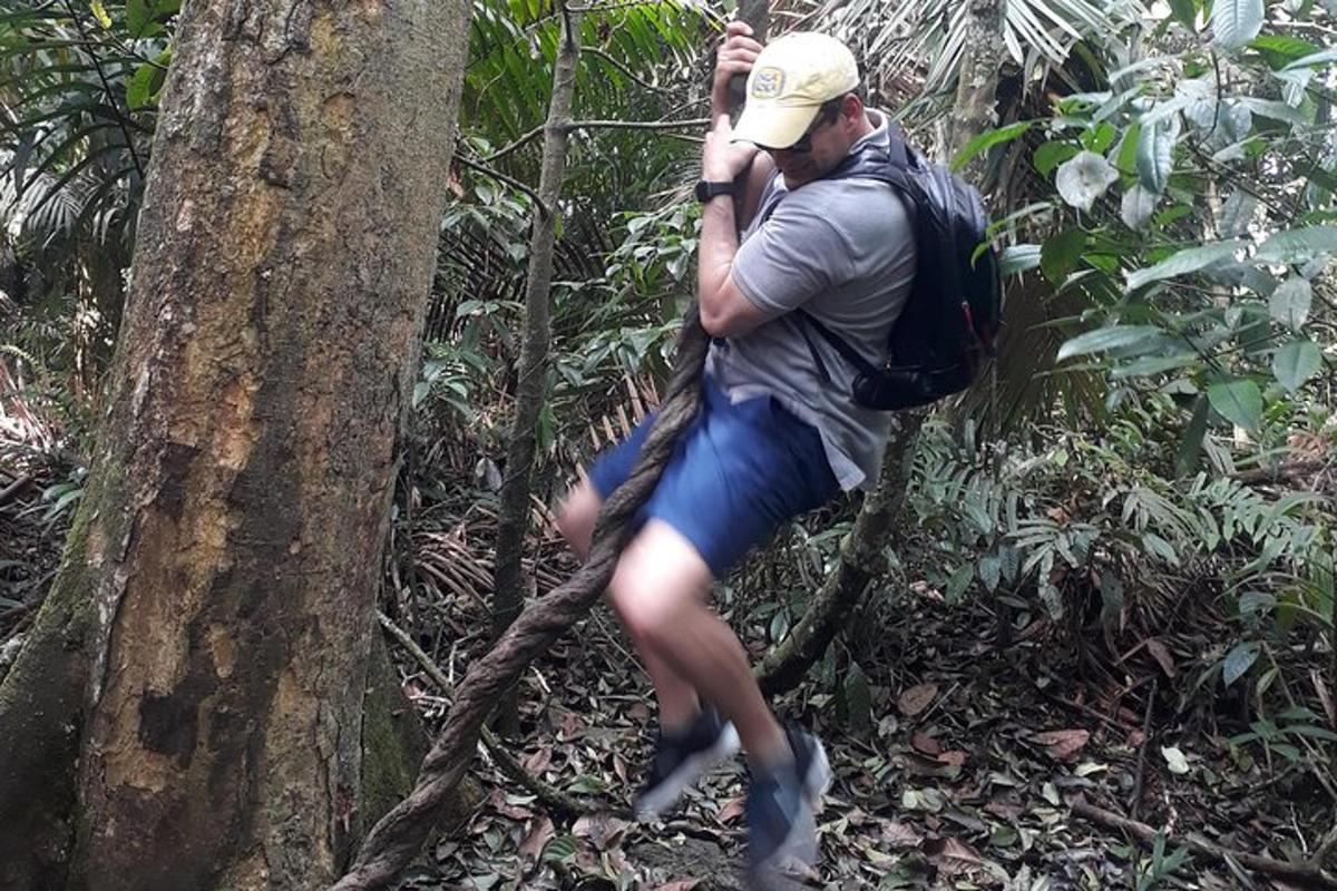 a man with a backpack talking on a cell phone in the forest