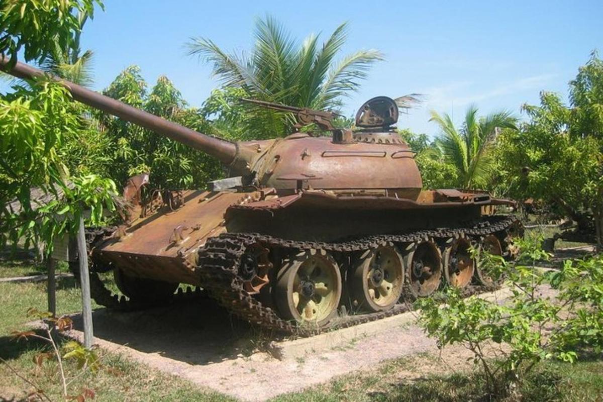 um tanque em exposição em frente a algumas árvores
