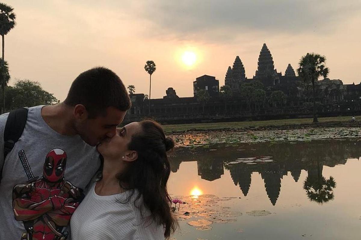 một người đàn ông và một người phụ nữ hôn nhau trước một vùng nước