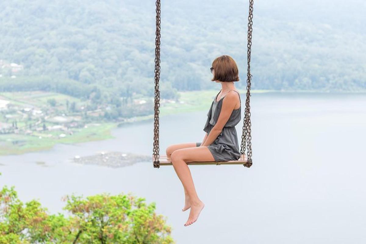 žena sedící na houpačce s výhledem na jezero