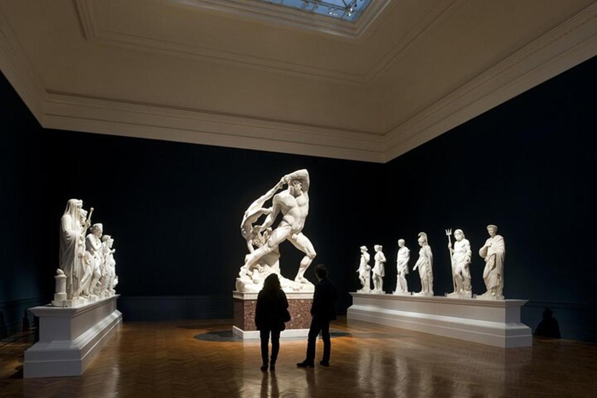 zwei Personen stehen vor einer Statue in einem Museum