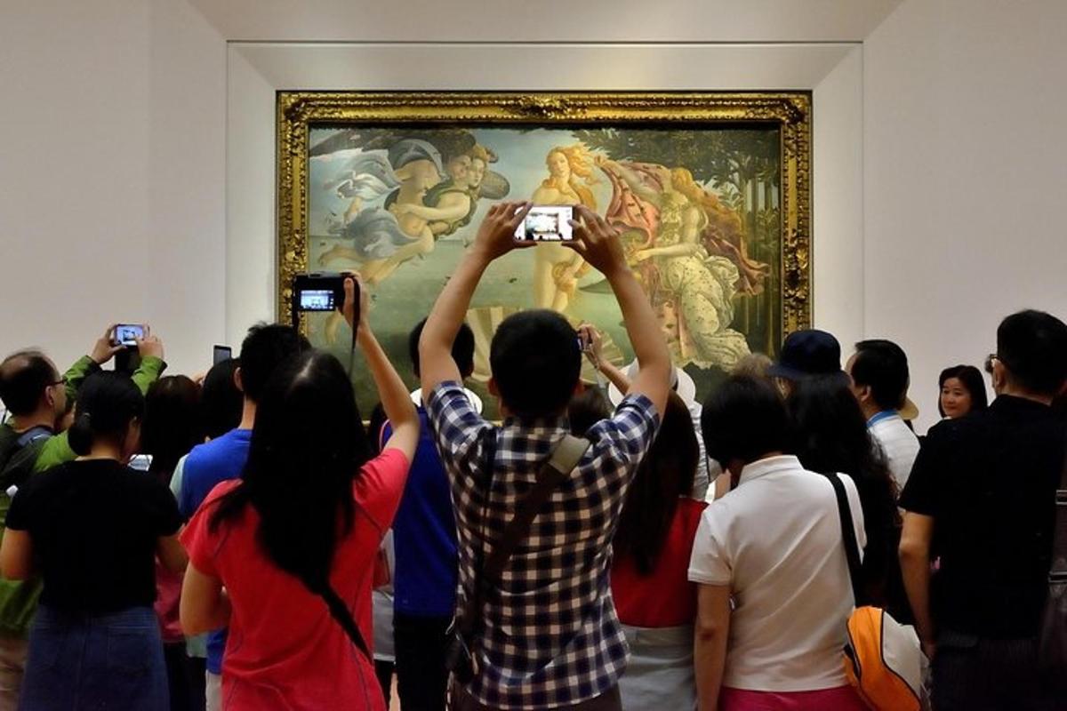 a group of people taking pictures of a painting