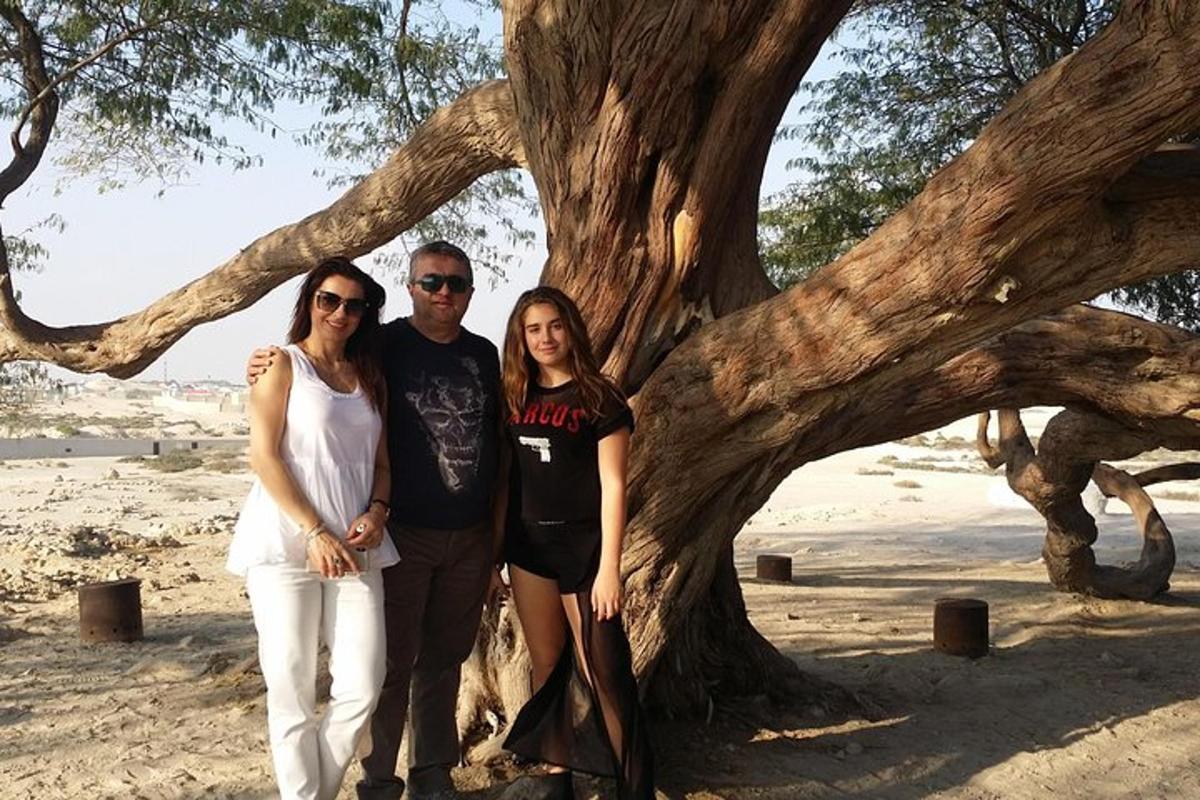 a man and two women standing next to a tree