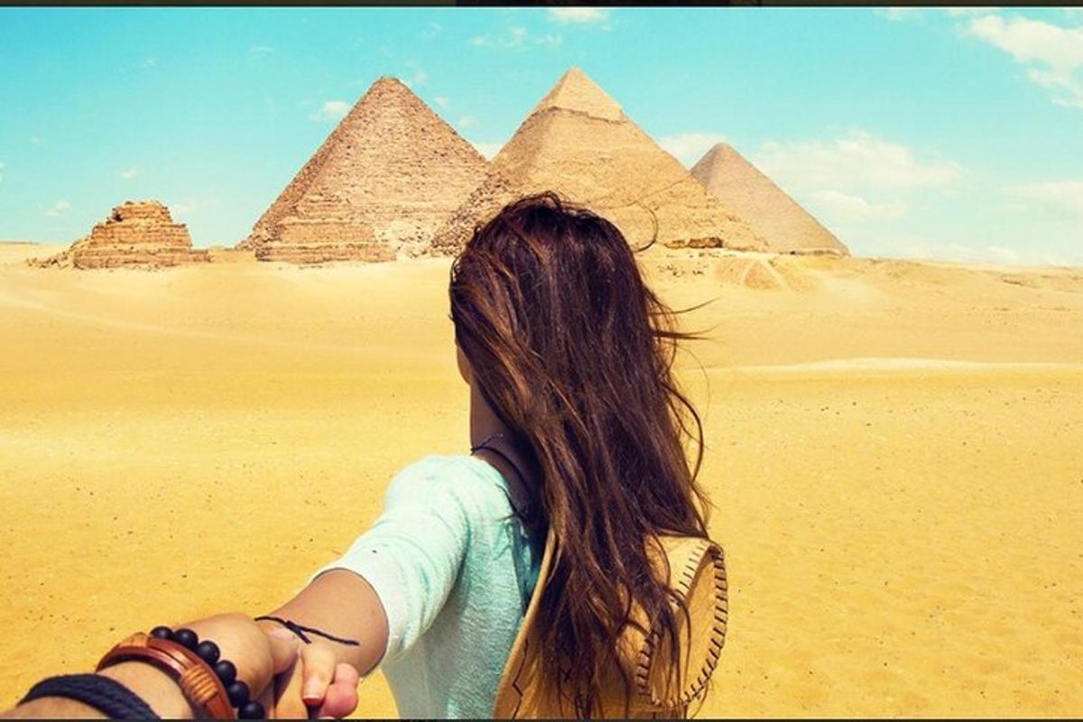 una donna che cammina davanti alle piramidi