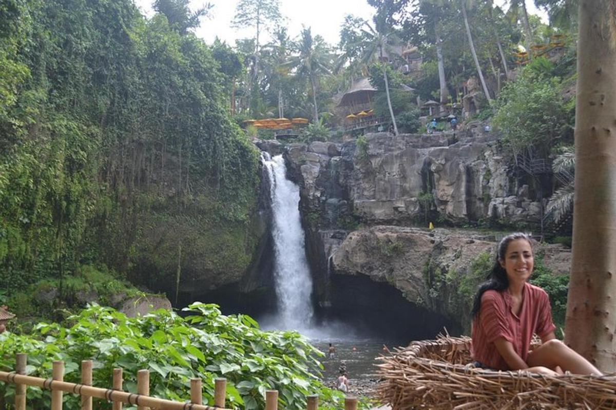 seorang wanita duduk di hadapan air terjun