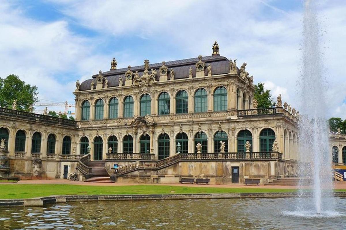 Un gran edificio con una fuente delante.