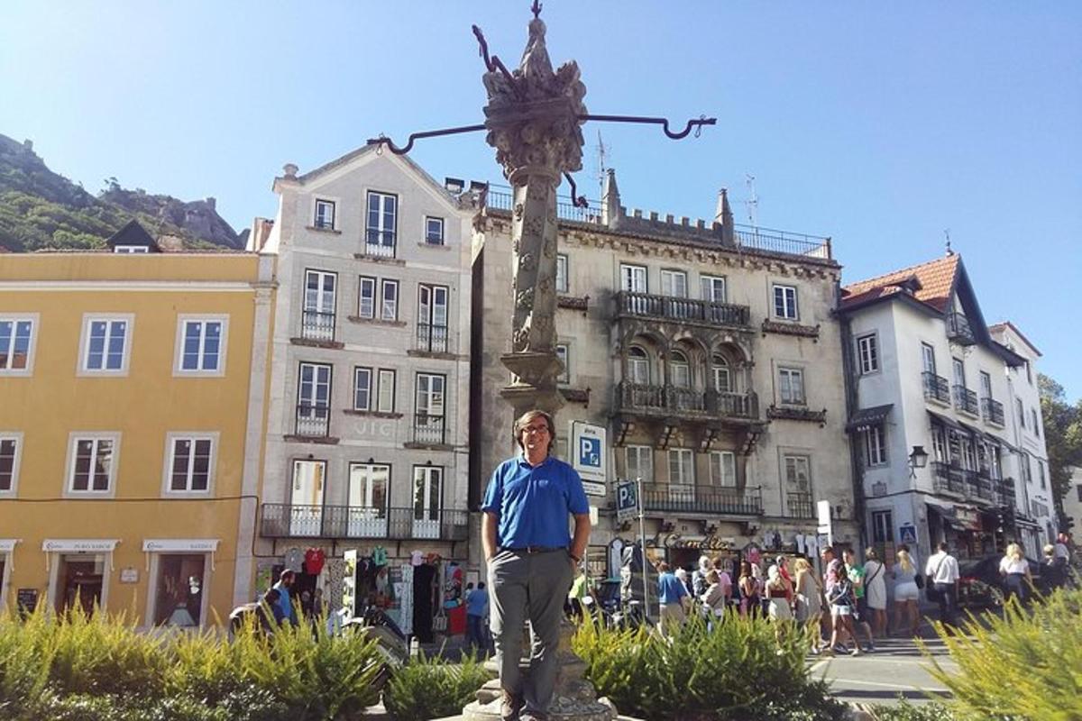 un uomo in piedi accanto a una statua di fronte a un edificio