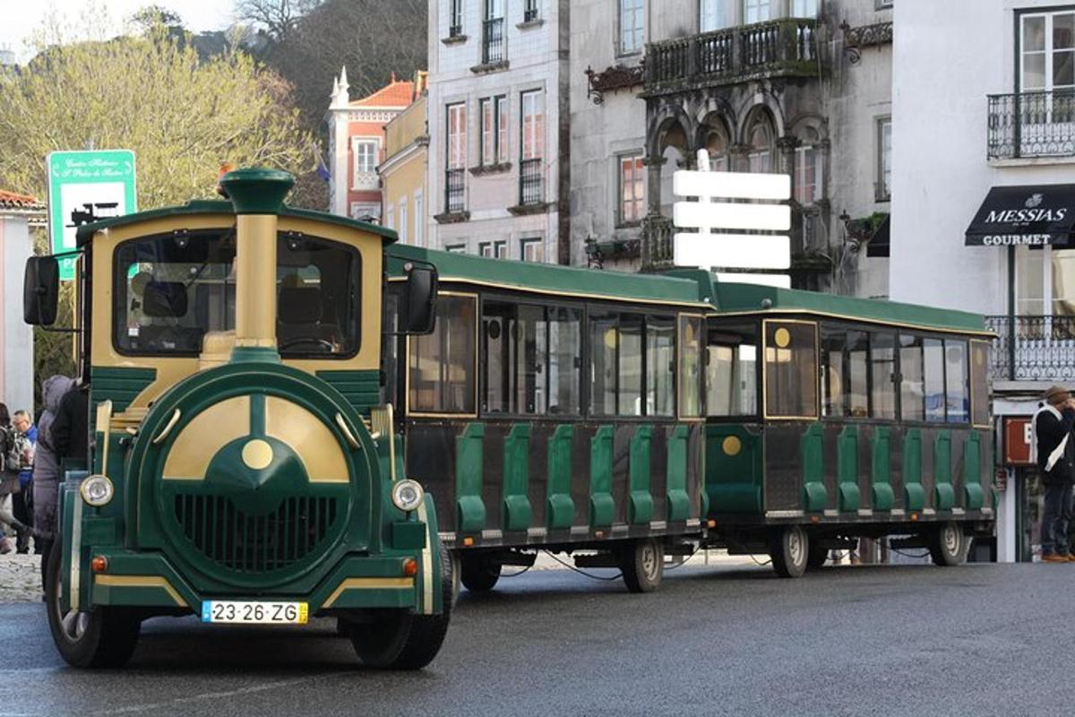 un treno verde e giallo che percorre una strada