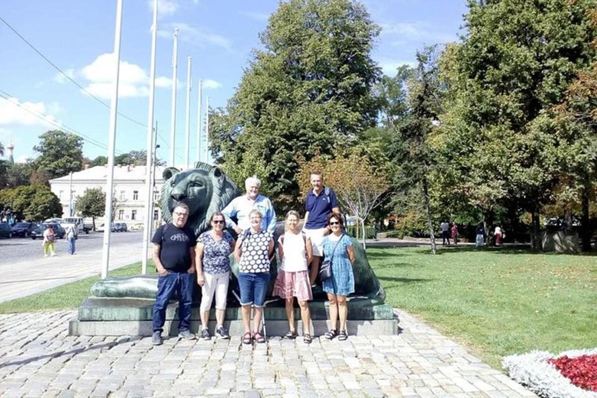 una famiglia posa davanti a una statua di leone