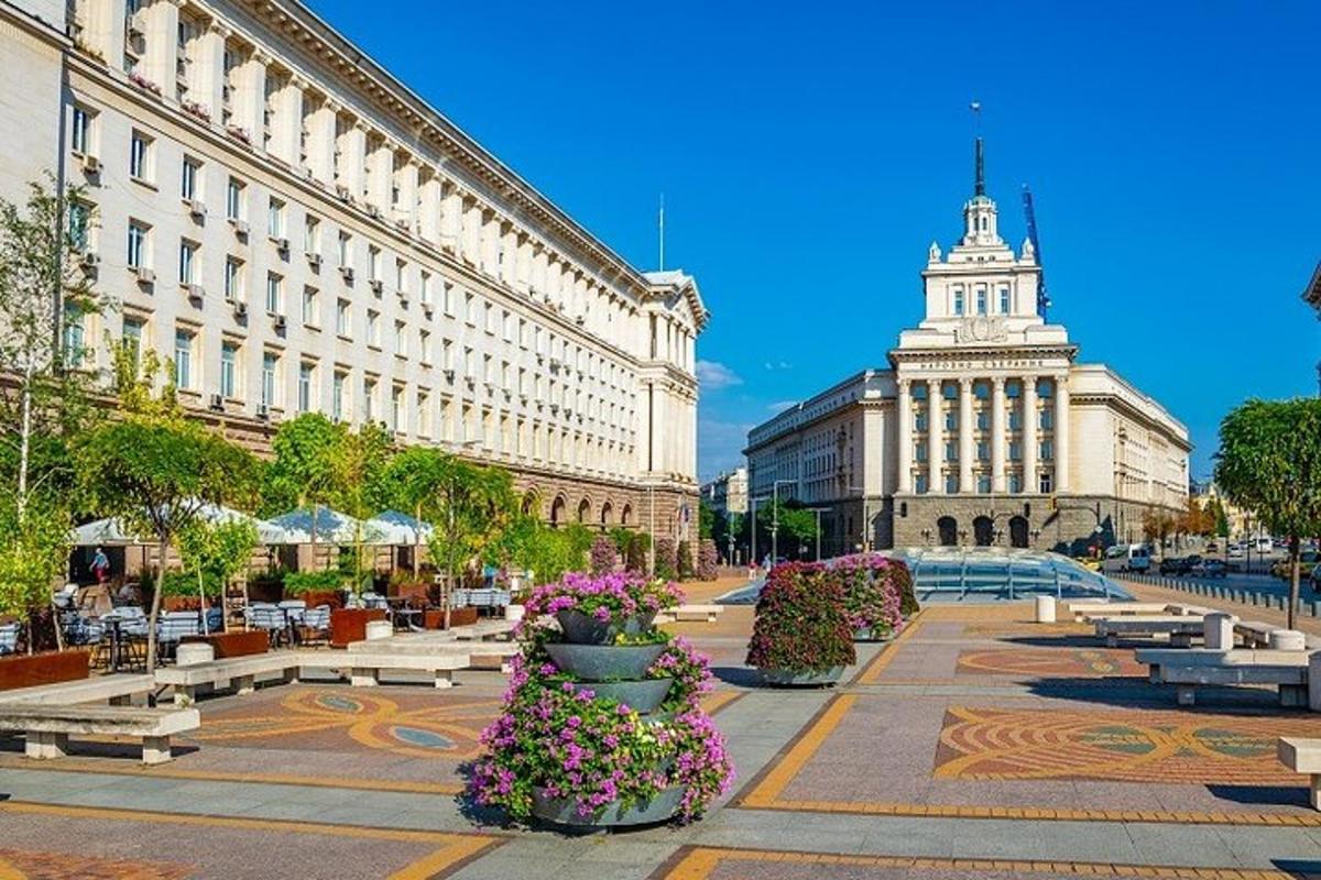 una strada con panchine e fiori davanti a un edificio