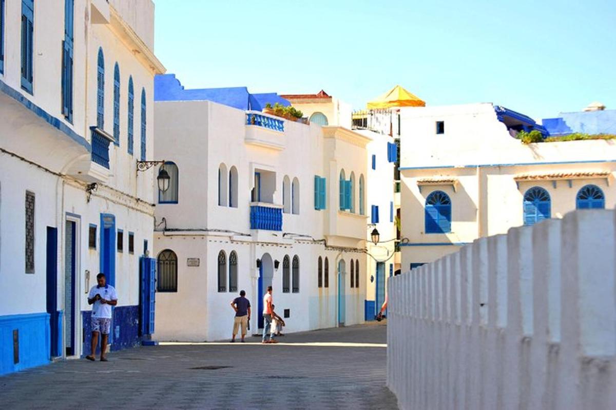 Un grupo de personas caminando por una calle con edificios.