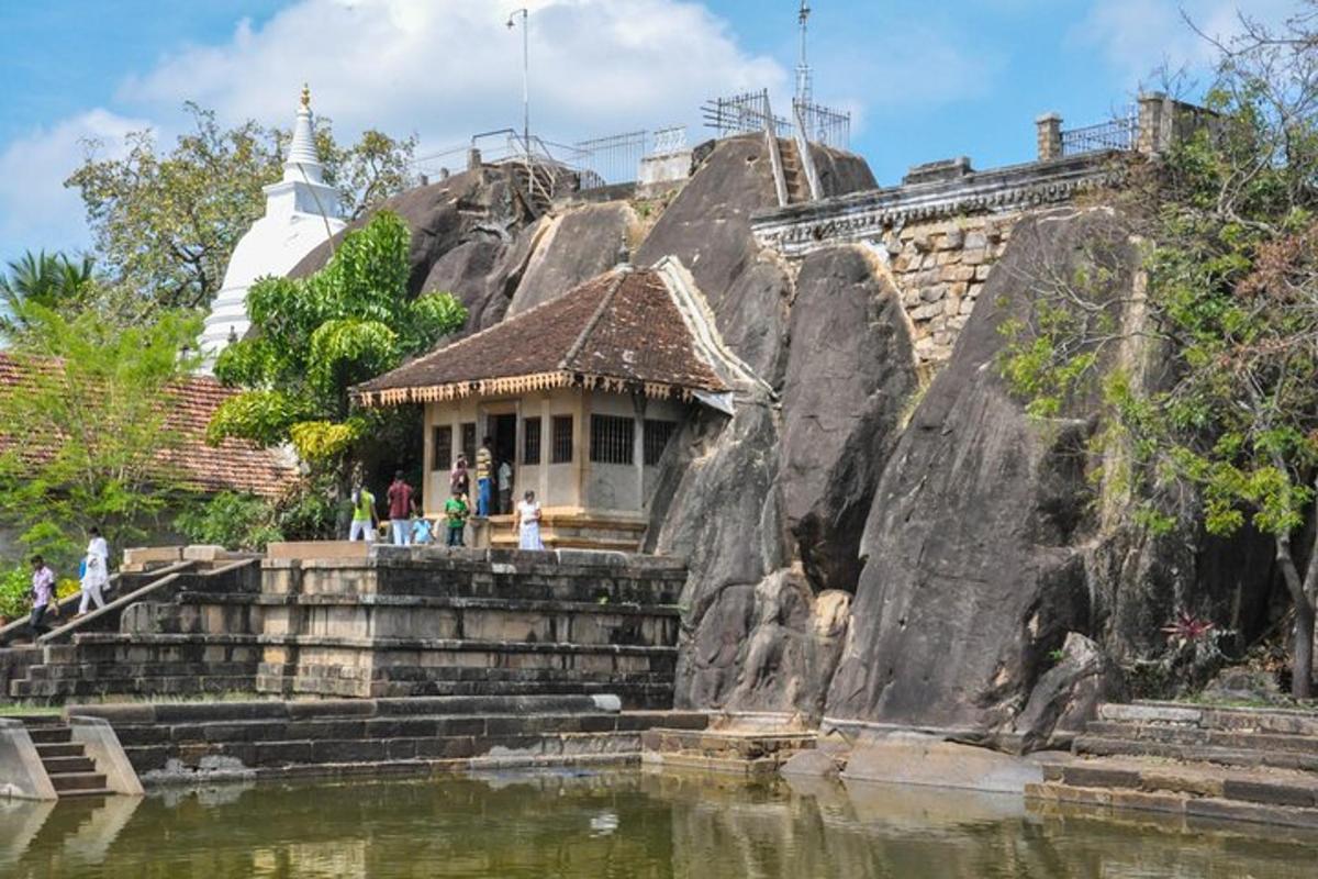 un petit edifici sobre una roca al costat de l'aigua