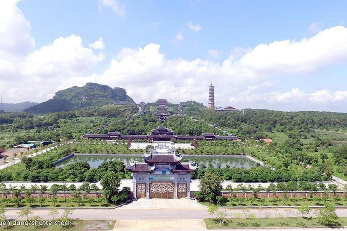 ein Gebäude in einem Park mit einem Hügel im Hintergrund