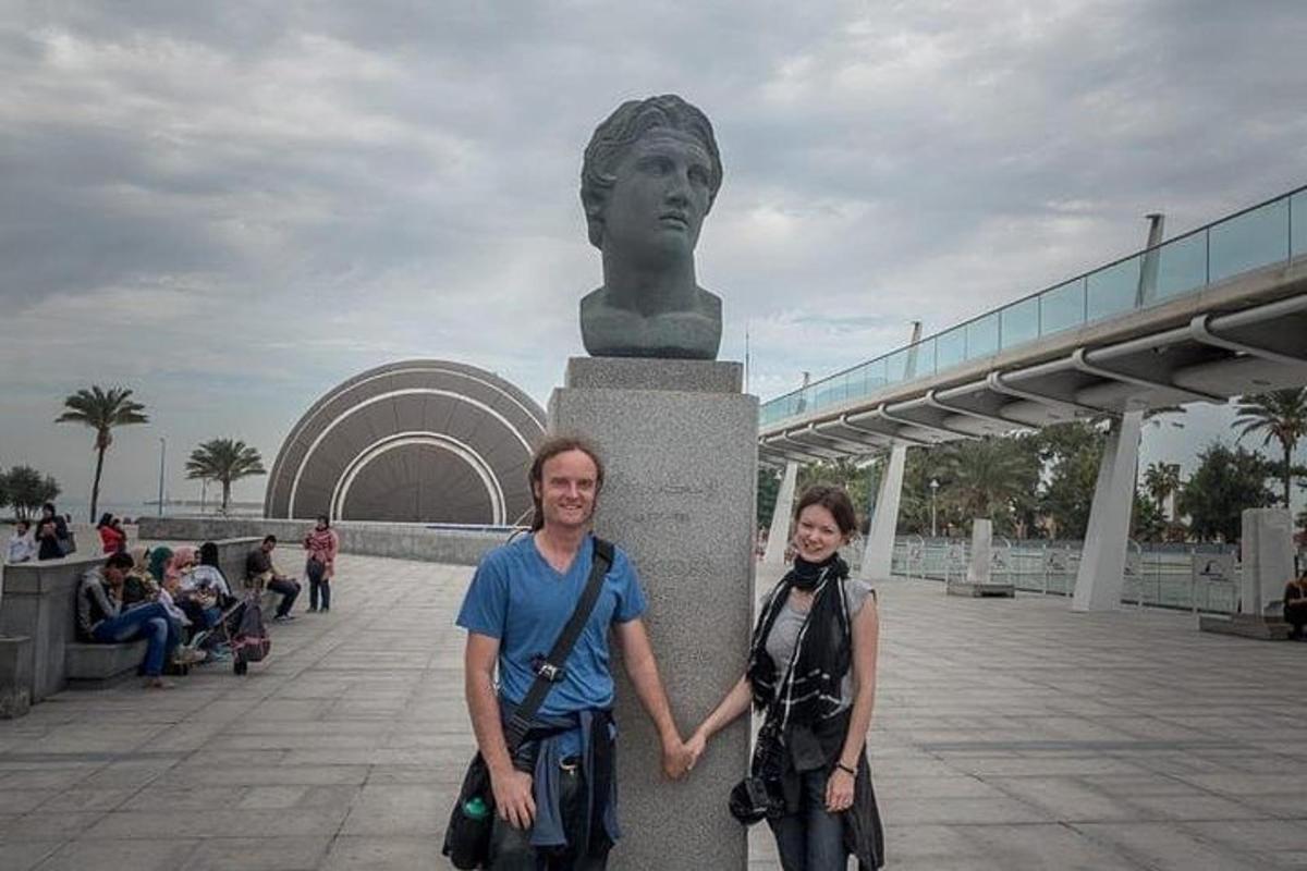 un uomo e una donna in piedi davanti a una statua