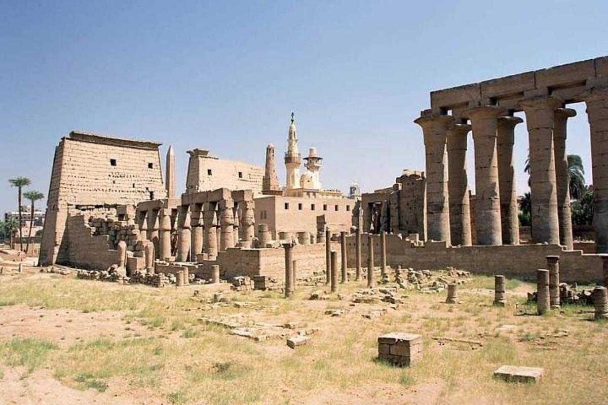 an ancient building with columns in a field