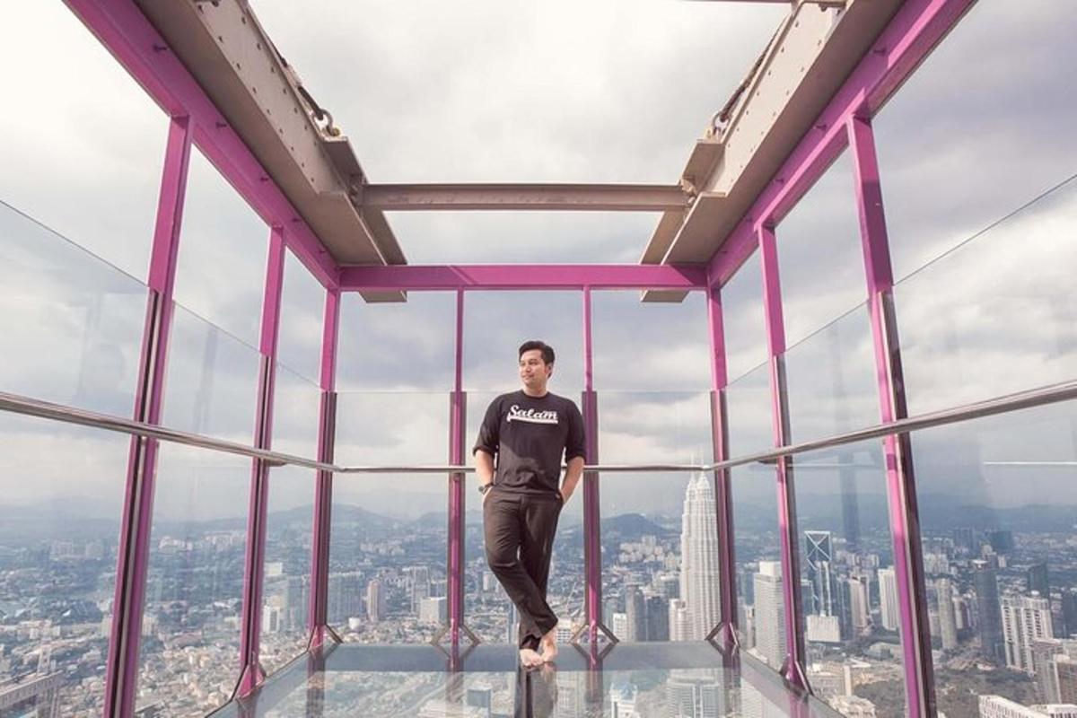 a man standing on the edge of a glass floor in the sky scrapper