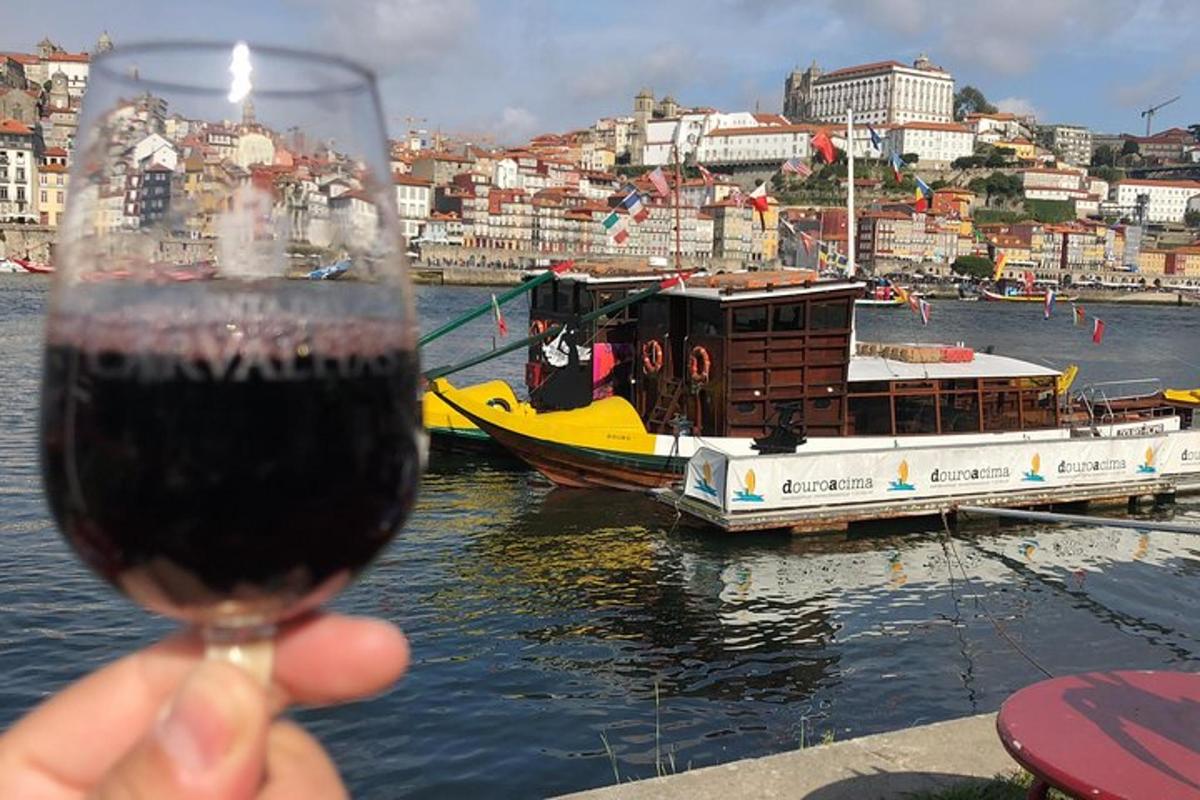 uma mão segurando uma taça de vinho com um barco