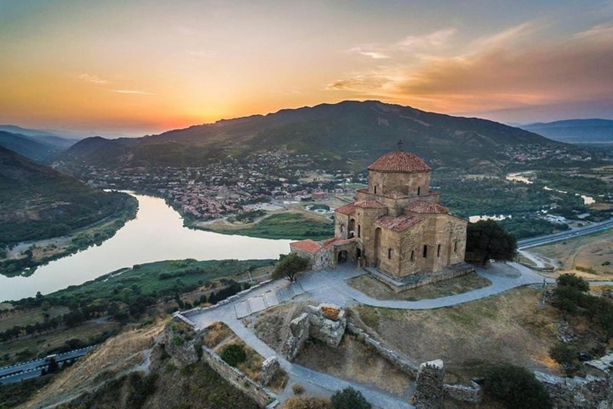 un edifici antic al cim d'un turó al costat d'un riu