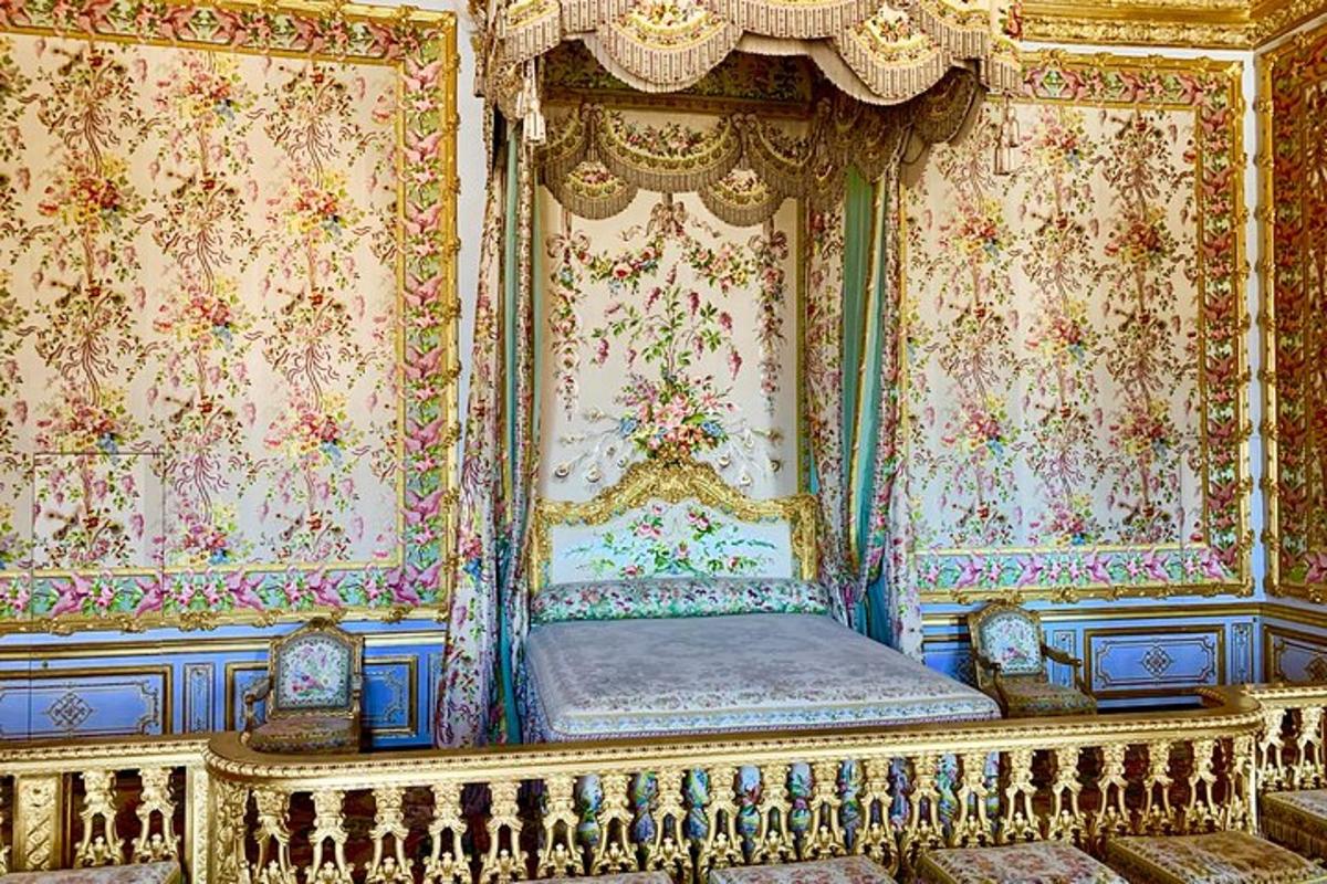 a bed in a room with ornate wallpaper