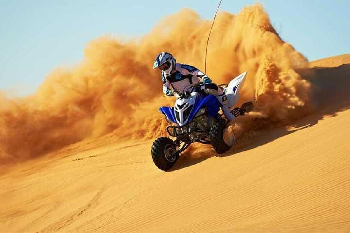 uma pessoa andando de moto no deserto