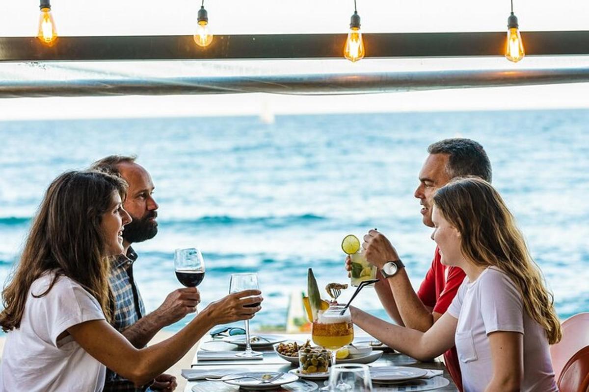 um grupo de pessoas sentadas à mesa com taças de vinho
