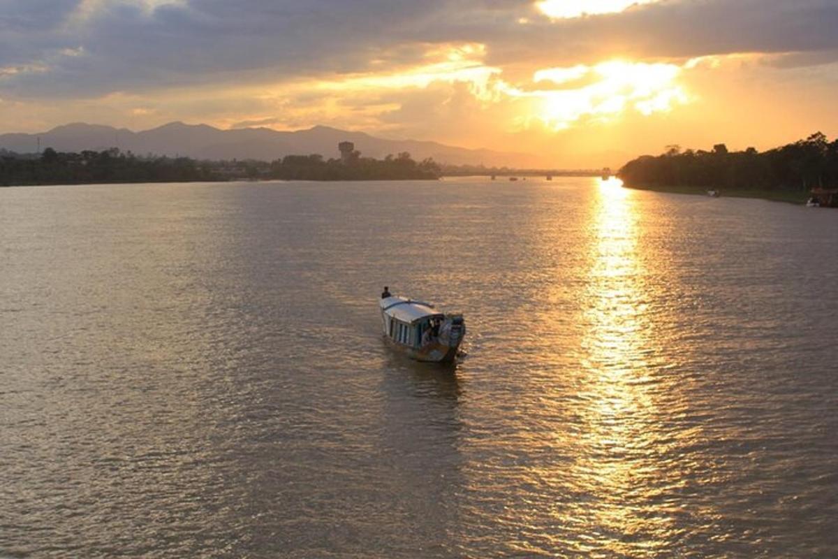 ein Boot mitten auf einem Fluss bei Sonnenuntergang